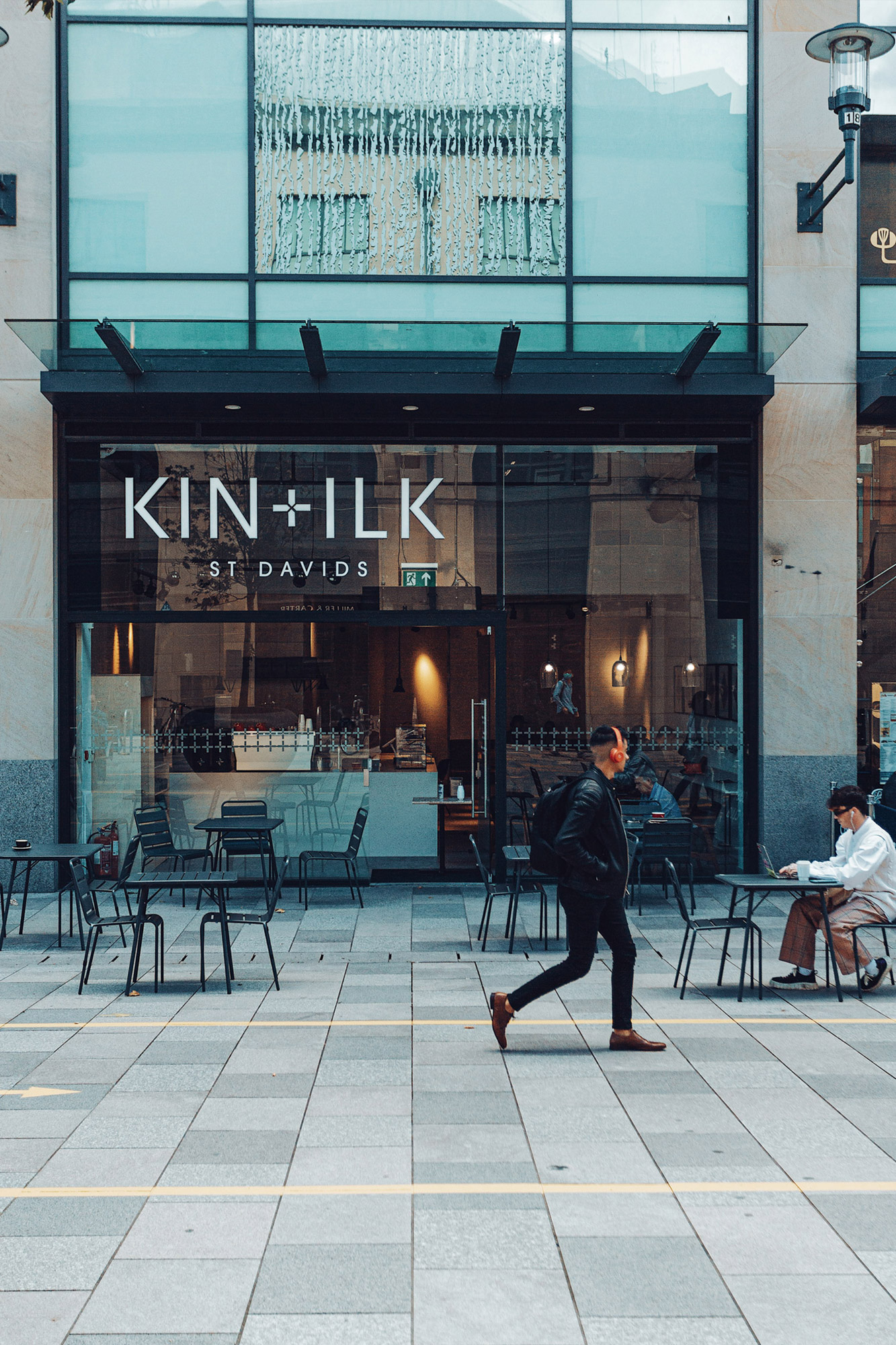 Shop front and pavement with one person walking by.